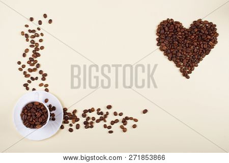 Roasted Brown Coffee Beans Laid Forming A Shape Of A Heart Next To Beautiful White Porcelain Coffee 