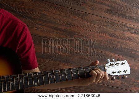 Hand Of Man Playing Six-string Guitar On Wooden Background. Template For Concert Poster