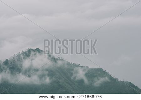 Thick Fog In Mountains With Copy Space On Mist. Vintage Foggy Landscape Of Majestic Nature In Faded 