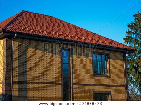 Two-storey House With Tall Vertical Window On The Stairwell, Rain-gutter And Show-guard On The Metal