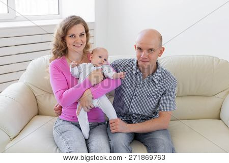 Family, Childhood And Parenthood Concept - Father, Mother Holding Cute Baby Indoors