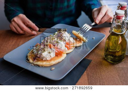 Woman Having A Pancake With Salmon And Sourcream In A Restaurant. Tasty Homemade Breakfast.
