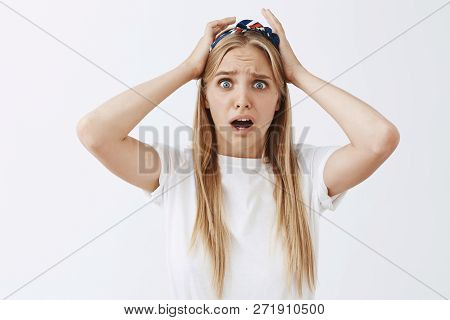 Waist-up Shot Of Concerned Panicking Young Feminine Blonde Woman In Headband Frowning And Dropping J