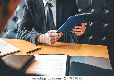Senior Manager Reading A Resume During A Job Interview Employee Young Man Meeting Applicant And Recr