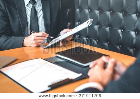 Senior Manager Reading A Resume During A Job Interview Employee Young Man Meeting Applicant And Recr