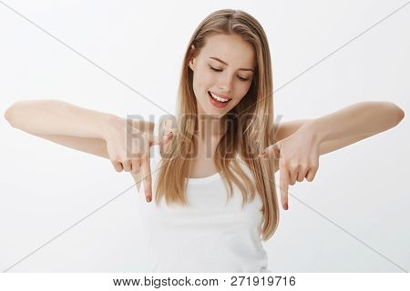Girl Intrigued What Lying Down Gazing With Interest And Pointing Downwards, Smiling Curious Explorin