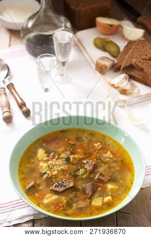 Rassolnik, Traditional Russian Soup, Served With Various Snacks And Vodka. Rustic Style.