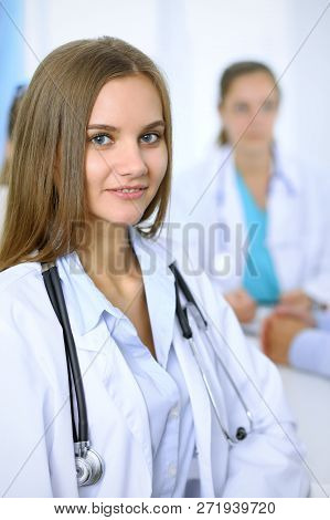 Happy Doctor Woman  With Medical Staff At The Background In Hospital Office