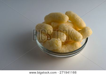 Corn Puffs In A Glass Bowl. Crunchy Flavored Puffed Snacks. Party, Movie Snacks.