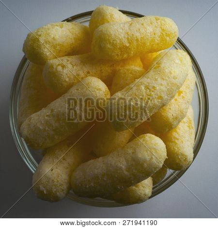 Corn Puffs In A Glass Bowl. Crunchy Flavored Puffed Snacks. Party, Movie Snacks.