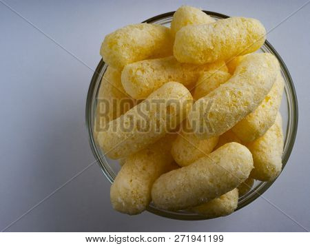 Corn Puffs In A Glass Bowl. Crunchy Flavored Puffed Snacks. Party, Movie Snacks.