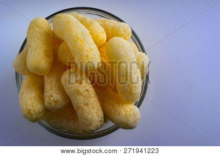 Corn Puffs In A Glass Bowl. Crunchy Flavored Puffed Snacks. Party, Movie Snacks.