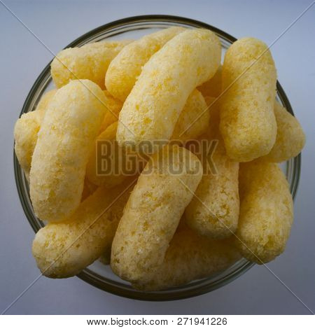 Corn Puffs In A Glass Bowl. Crunchy Flavored Puffed Snacks. Party, Movie Snacks.