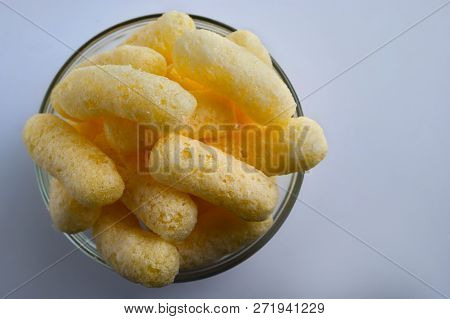 Corn Puffs In A Glass Bowl. Crunchy Flavored Puffed Snacks. Party, Movie Snacks.