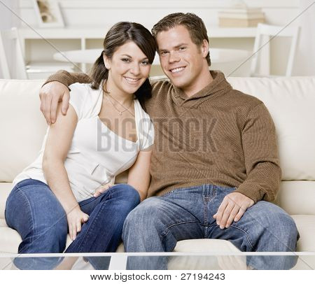 Молодая пара, обниматься на диване