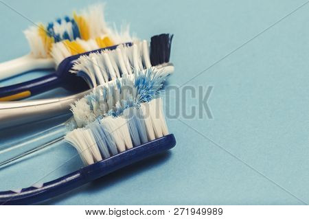 Several Different Used Toothbrushes On A Blue Background. Toothbrush Change Concept, Oral Hygiene, B