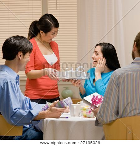 Donna generosa dà il regalo a sorpreso fra i tuoi amici alla festa di compleanno