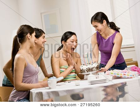 Donna generosa sorprendente amico con torta di compleanno alla festa