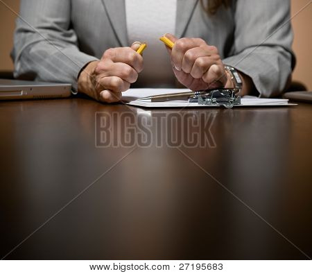 Vred og frustreret forretningskvinde arbejder sent bryde blyant i receptionen