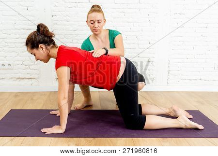 Coach Instructor Teaching Young Woman To Stretch Back In Pilates Yoga Cow Pose In Healthy Lifestyle
