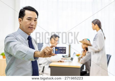 Portrait of Young adult Patient with credit card with examination room medical office background for insurance concept