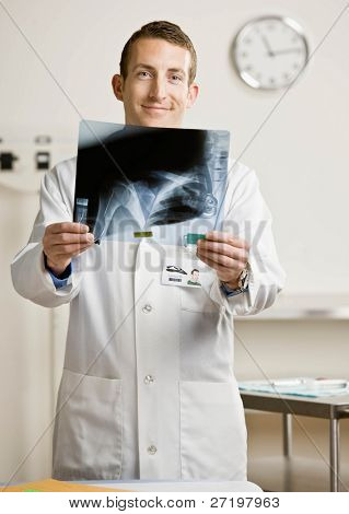 Jistý lékař v laboratorní plášť a stetoskop zkoumání rentgen kostí v ordinaci lékaře