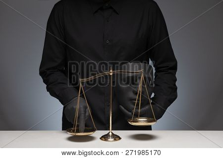 Man Holding Black Evil Mask In One Hand Pressing The Scale On The Gray Background With Invisible Fac