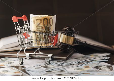 Judge Gavel, Scale Of Justice With Usa Dollars And Law Book On Judges Table In Courtroom. Conceptual