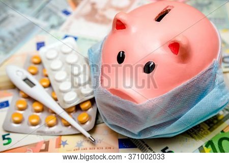 Piggy Bank In A Mask On A Background Of European Currency.the Concept Of Coronavrius Epidemic