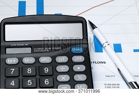 Calculator On Financial Papers At The Table Close Up