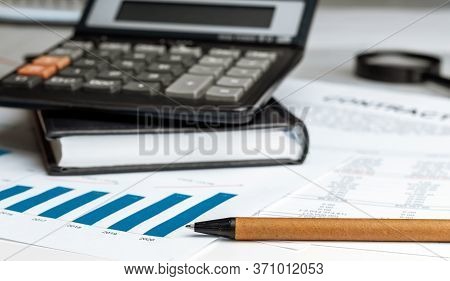 Calculator On Financial Papers At The Table Close Up. Finance Concept