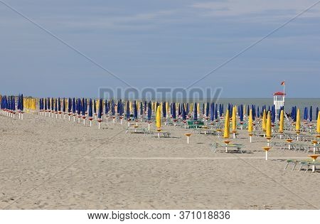 Deserted Beach With Very Few People And Closed Sun Umbrellas Due To The Terrible Economic Crisis Cau