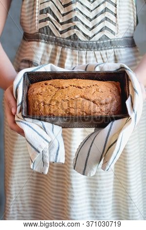 Young Woman's Hands Holding A Freshly Baked Loaf Of Homemade Pumpkin Bread Baked In A Vintage Bread 