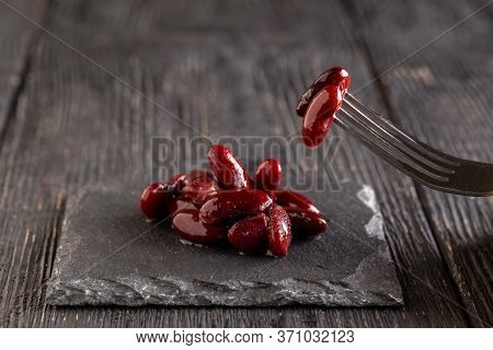 Side View On Eating Natural Cooked Red Beans On A Black Board On The Dark Wooden Background, Horizon