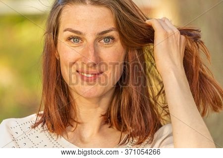 Portrait Of A Young Red-haired Girl, Girl Looking At The Camera, Straightens Hair And And Smiling Sh