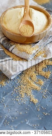 Bowl Of Raw Amaranth Flour With A Spoon Of Amaranth Seeds On A Grey Table Close Up