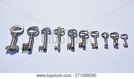 Ten Small Antique Pipe Keys On White Background