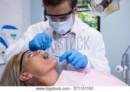 Close up of dentist examining woman at clinic