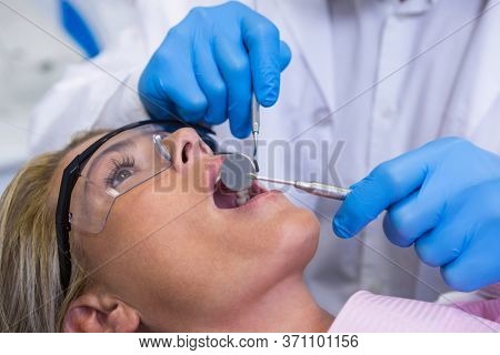Close up of doctor examining woman at dental clinic