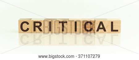 Critical Word Written On Wood Block. Critical Text On Table, Concept.