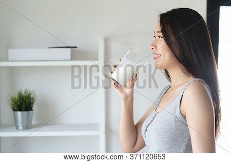 Healthy Beautiful Asian Woman Drinking Plain Fresh Milk In The Morning.