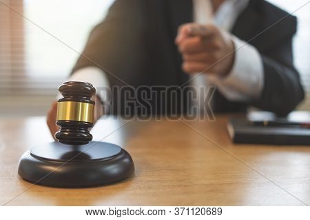 Close Up View Of Auction Hammer On The Desk In Lawyer Office And Lawyer Writing Document As Backgrou