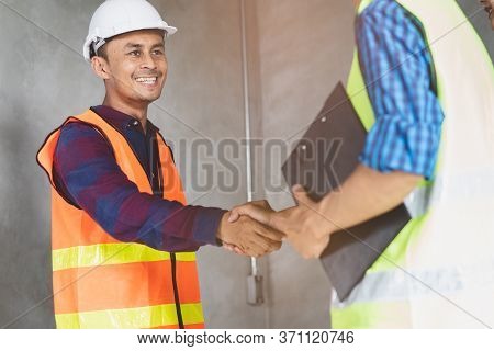 Construction Worker And Contractor. Client Shaking Hands With Team Builder In Renovation Site.