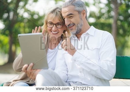 Technology Connect And Modern Elderly Lifestyles Concept. Aged Senior Couple Waving Hands Greeting G