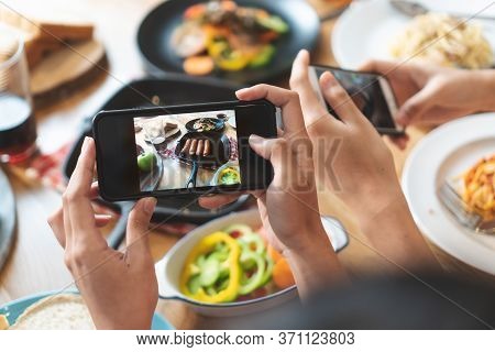 Social Media And Modern People Lifestyles. Close Up Hands Of Food Blogger Influencers Taking Picture