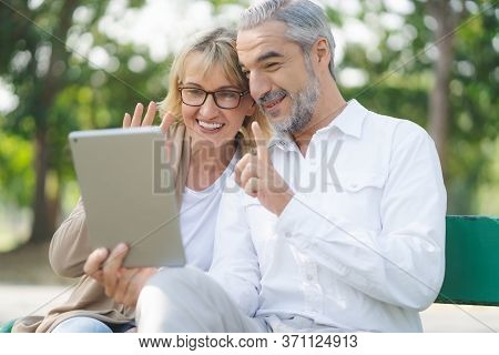 Technology Connect And Modern Elderly Lifestyles Concept. Aged Senior Couple Waving Hands Greeting G