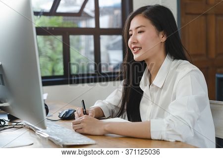 Working From Home Using Internet Communication Concept. Asian Young Woman Wear Earphones Talking  In