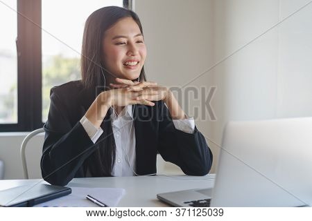 Working From Home Using Internet Communication Concept. Asian Young Woman Wear Earphones Talking  In