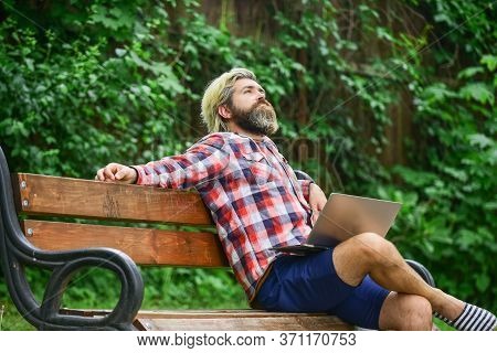 Doing Research. Successful Entrepreneur. Mature Man Sitting On Park Bench With Laptop And Checking E