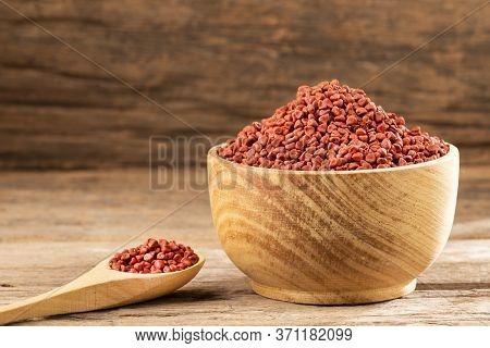 Bixa Orellana - Organic Annatto Seeds. Wood Background